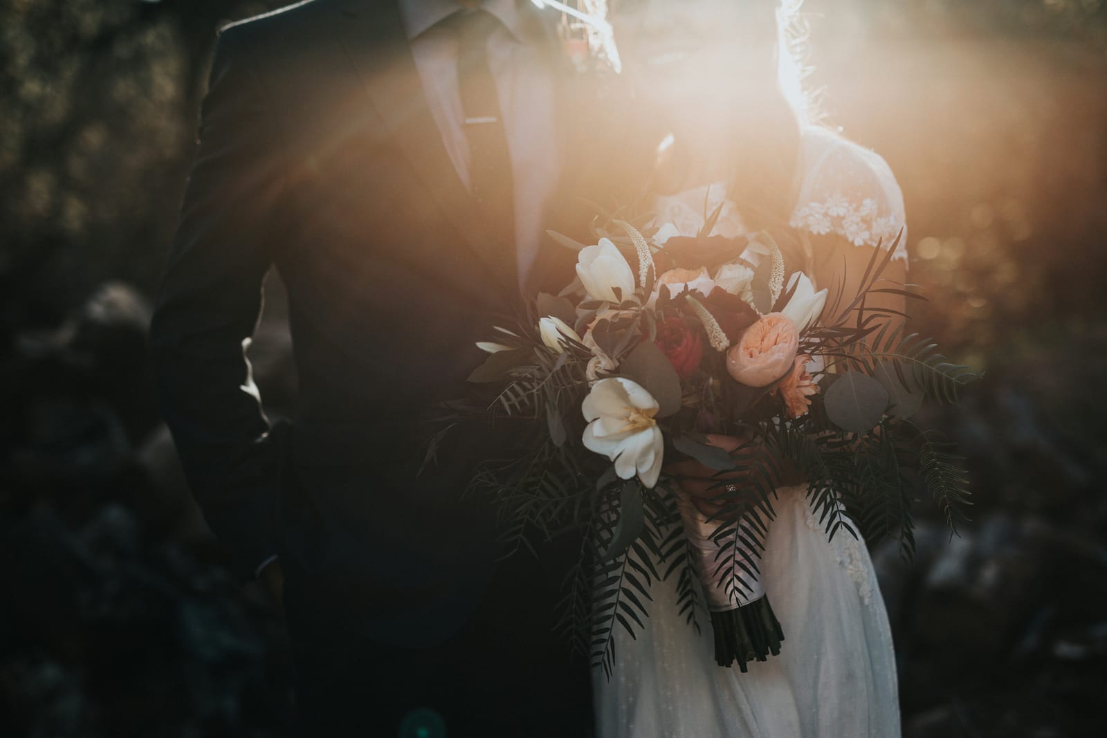 Couple with bouquet in golden hour
