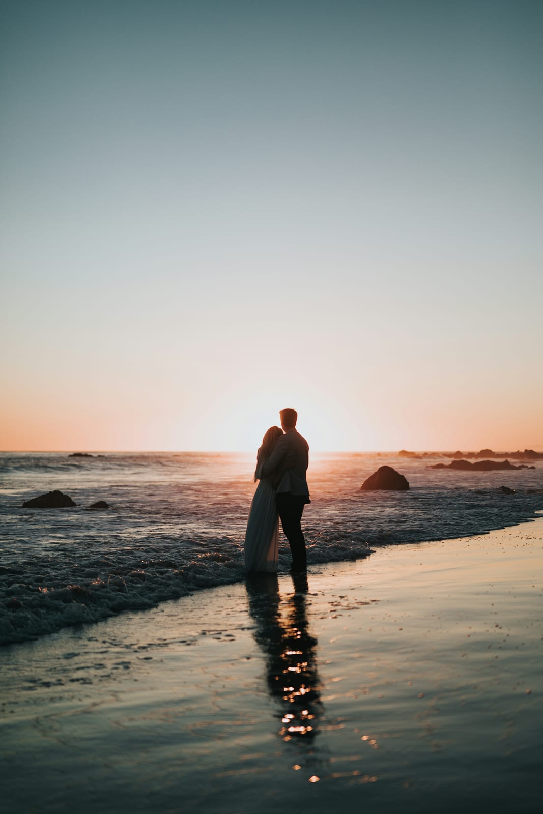 Couple silhouetted on the beach